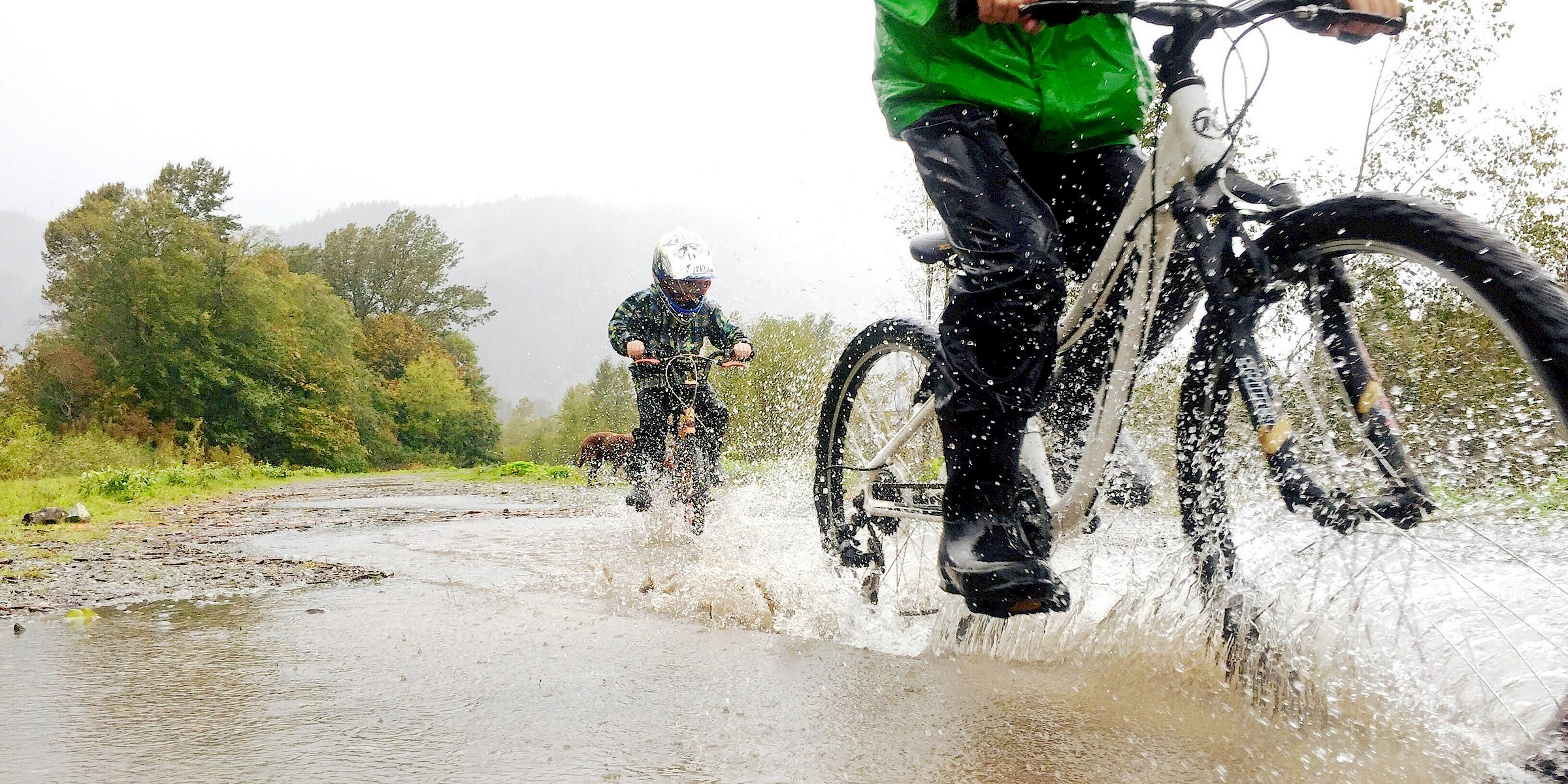 Family biking through puddles on a rainy day in Squamish