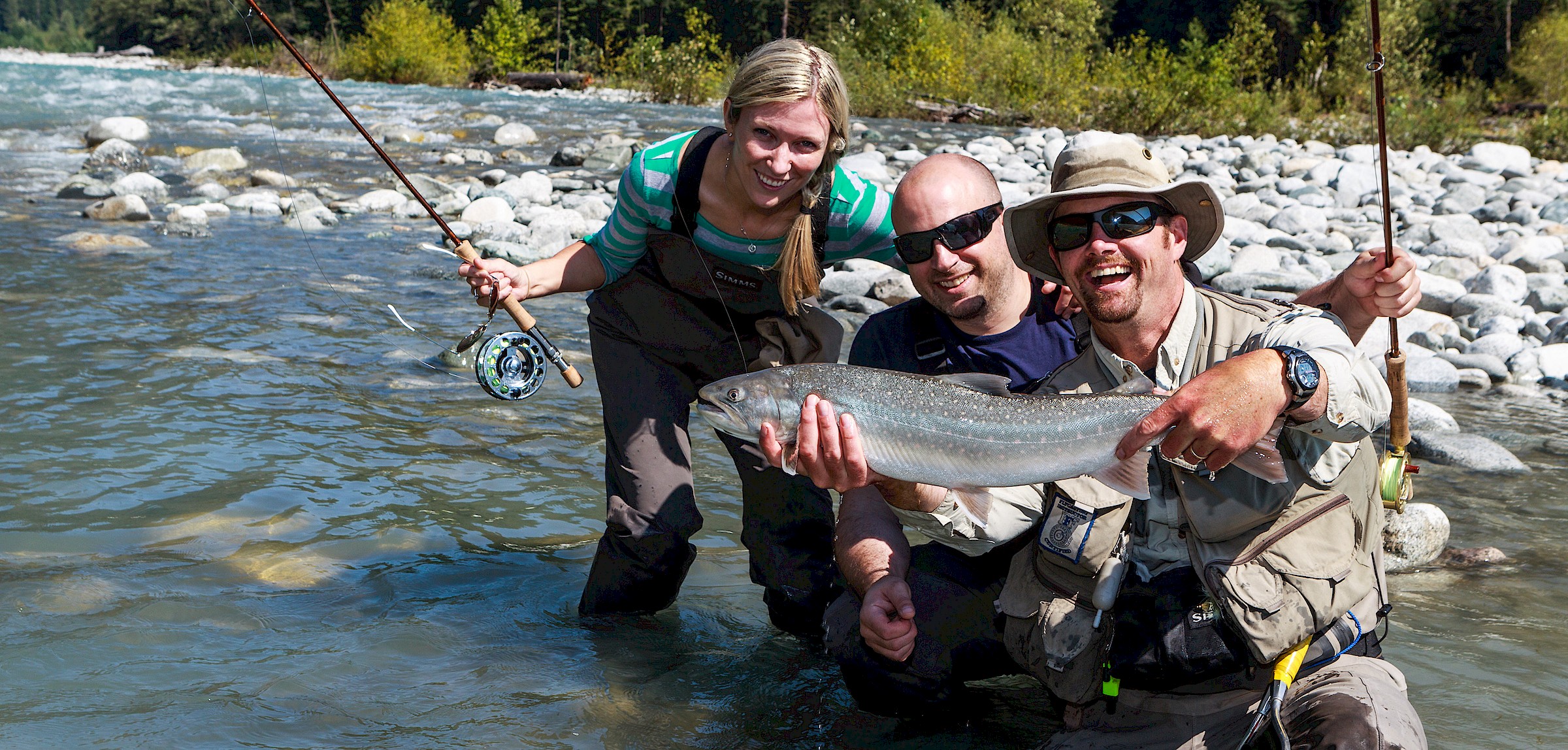 Happy fishing group in a river showing off their catch