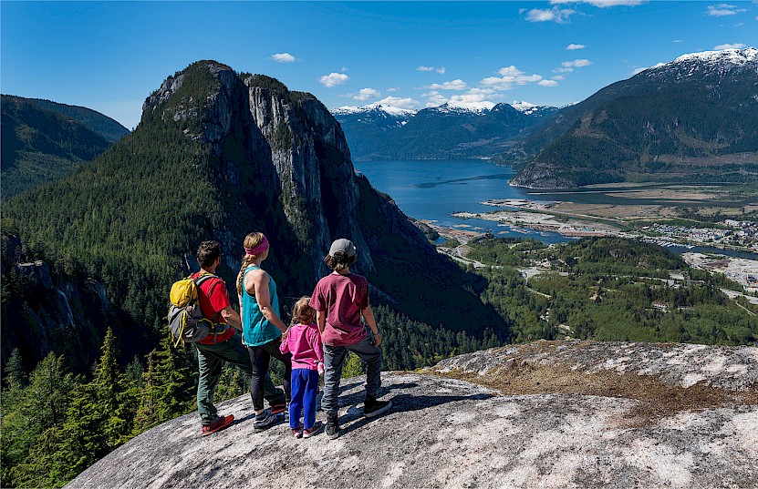 Family at the top of the Slhanay taking in the view of Squamish