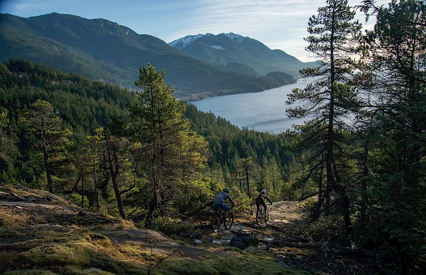 Couple mountain biking with a view of Howe Sound