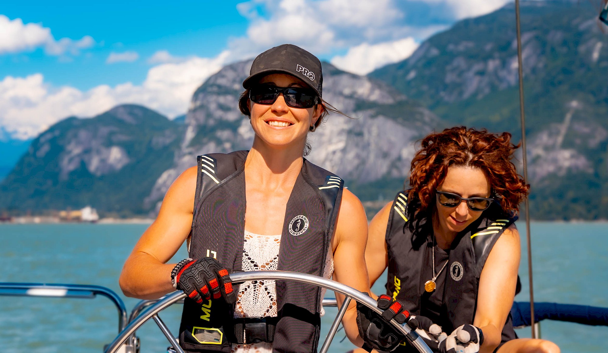 Two women on a sailboat with Stawamus Chief in the background
