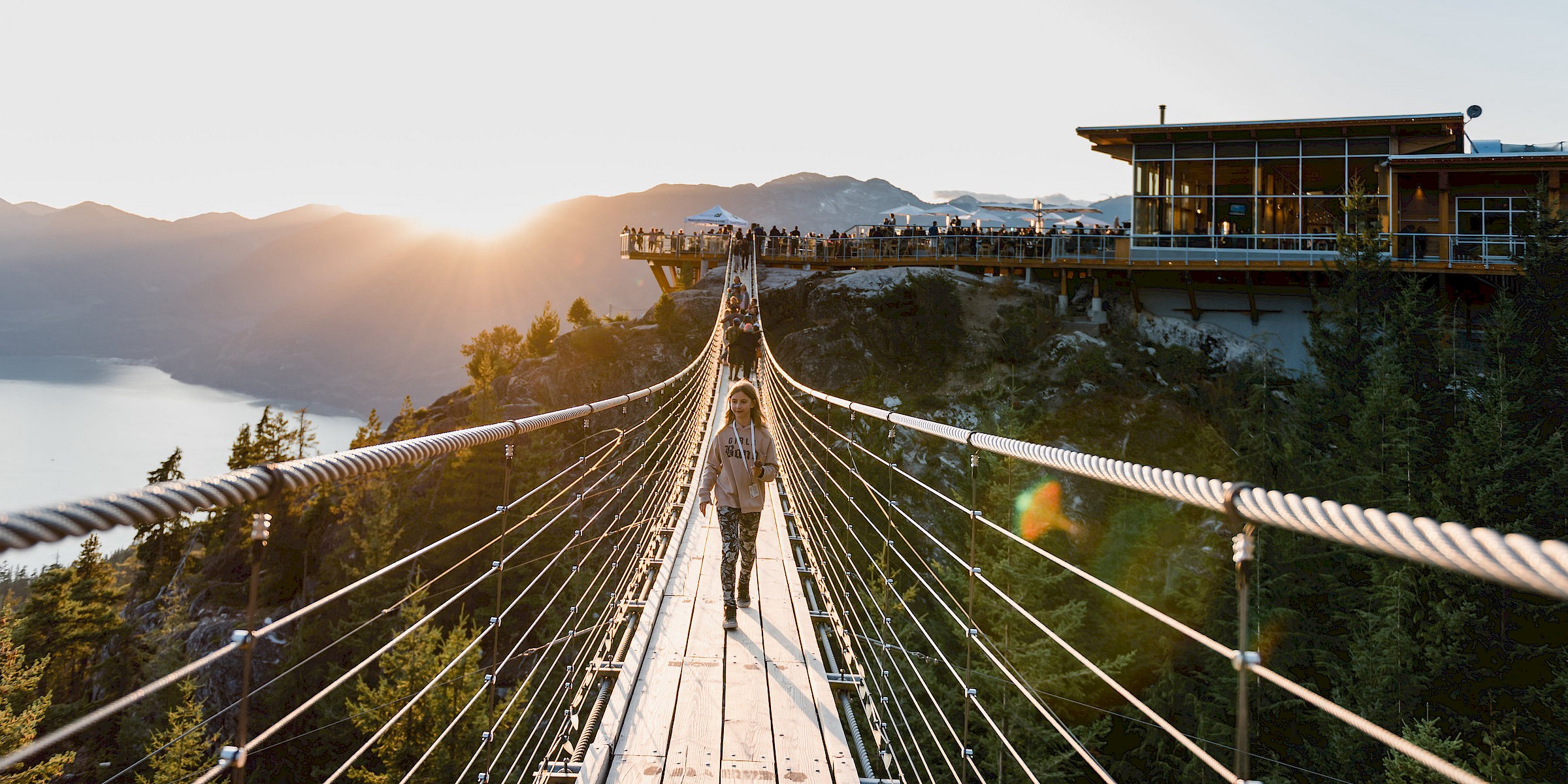 Girl walking across the Sea to Sky gondola at sunset