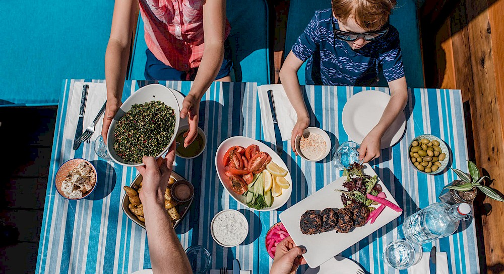 Family enjoying a meal in the sun at Saha in Squamish