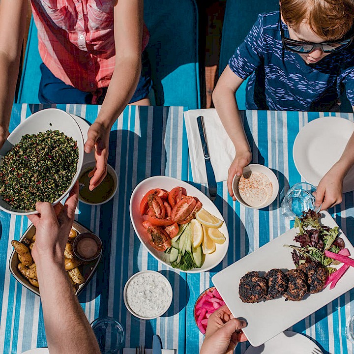 Family enjoying a meal in the sun at Saha in Squamish