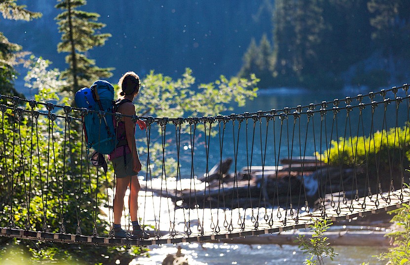 Hiker crossing a bridge on the trails near Alpha