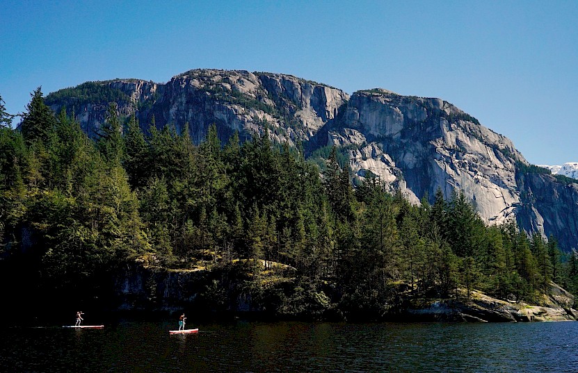 Stand up paddle boarders paddling with the Stawamus Chief in the background