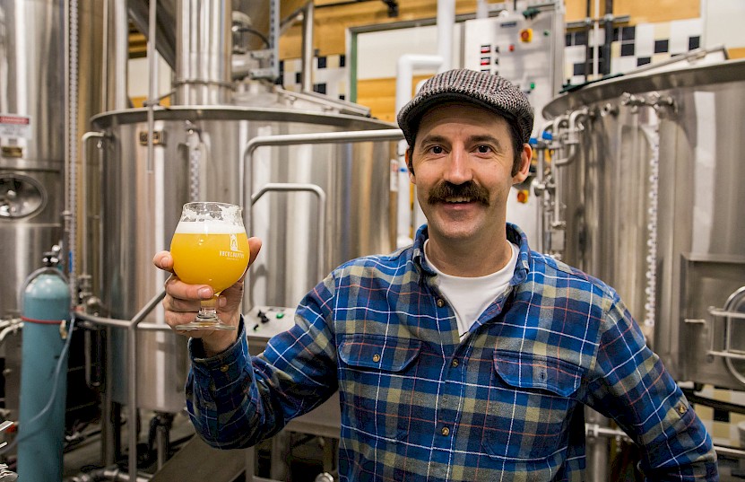 Man raising a beer glass in Backcountry Brewery