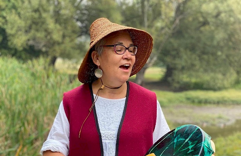 Woman singing and playing traditional drum