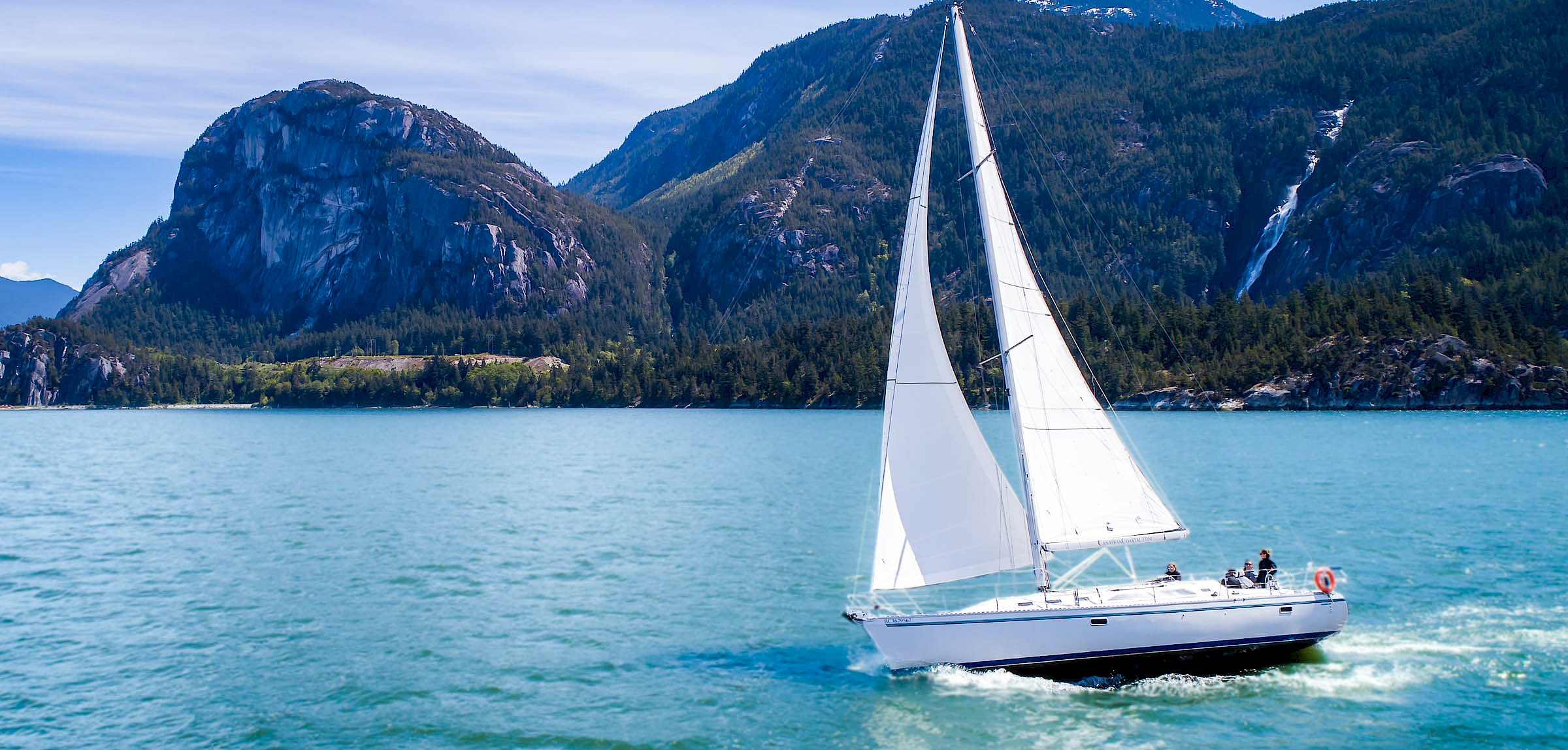 Sail boat on the Howesound with a backdrop of the Stawamus Chief