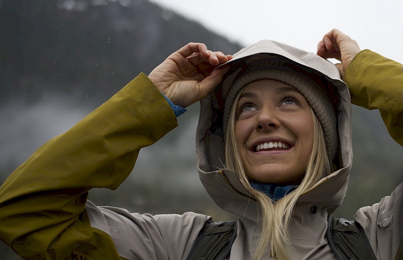 Woman pulling on her jacket's hood in the rain