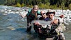 Happy fishing group in a river showing off their catch