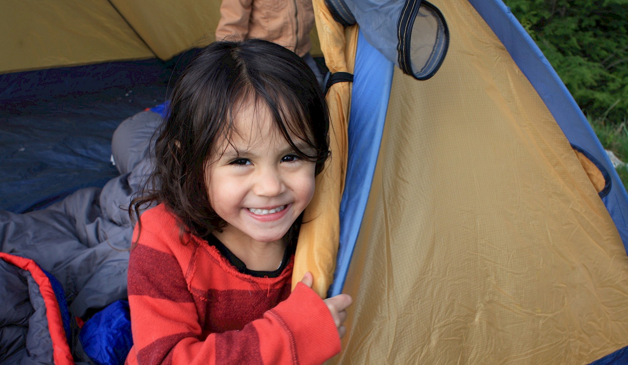 Girl smiling from her tent while camping