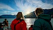 People overlooking the water and mountains