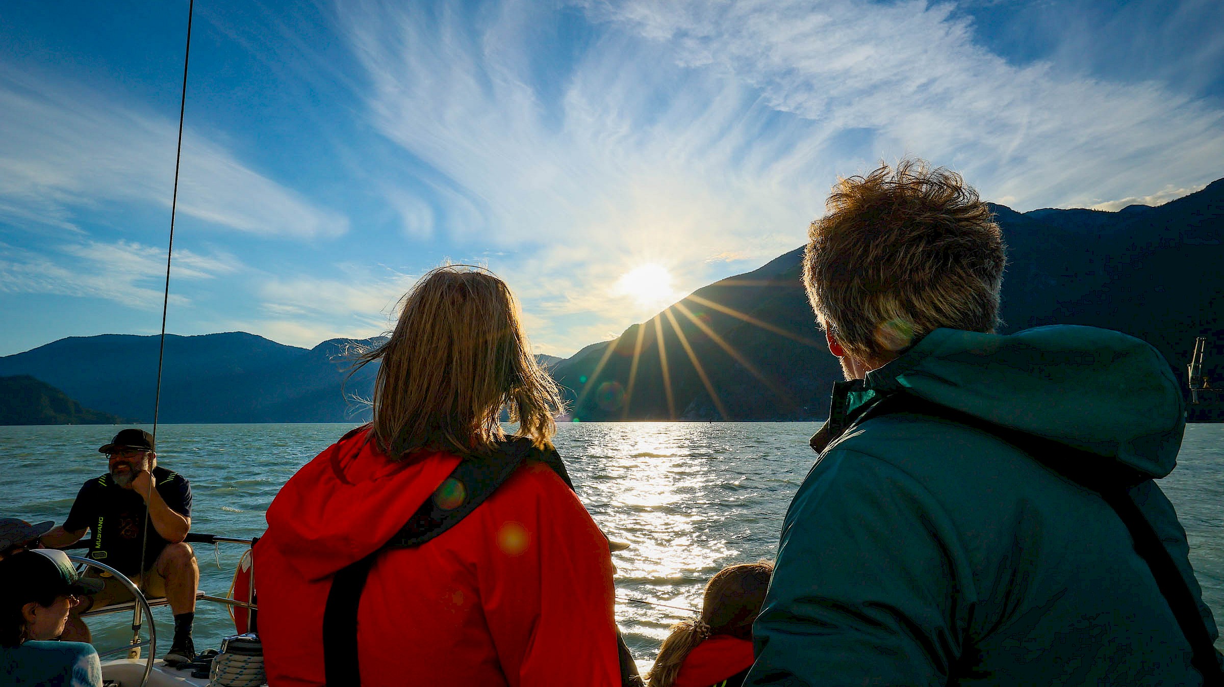 People overlooking the water and mountains