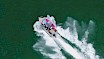 Shot from above of a boat with two paddle boards moving through the water of the Howe Sound