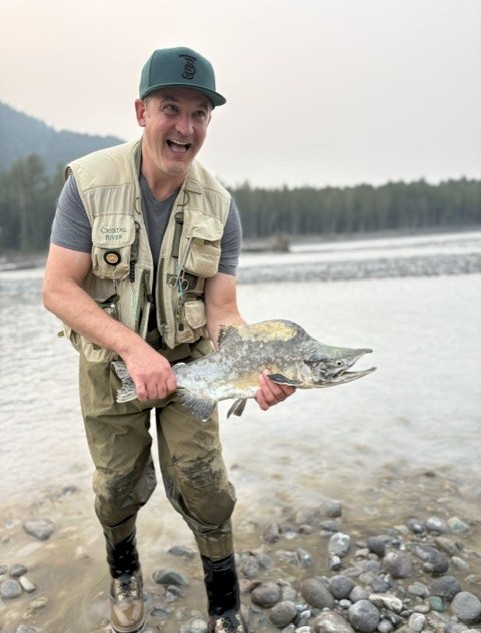 A fly fisherman holding a pink salmon during the October 2025 salmon run.
